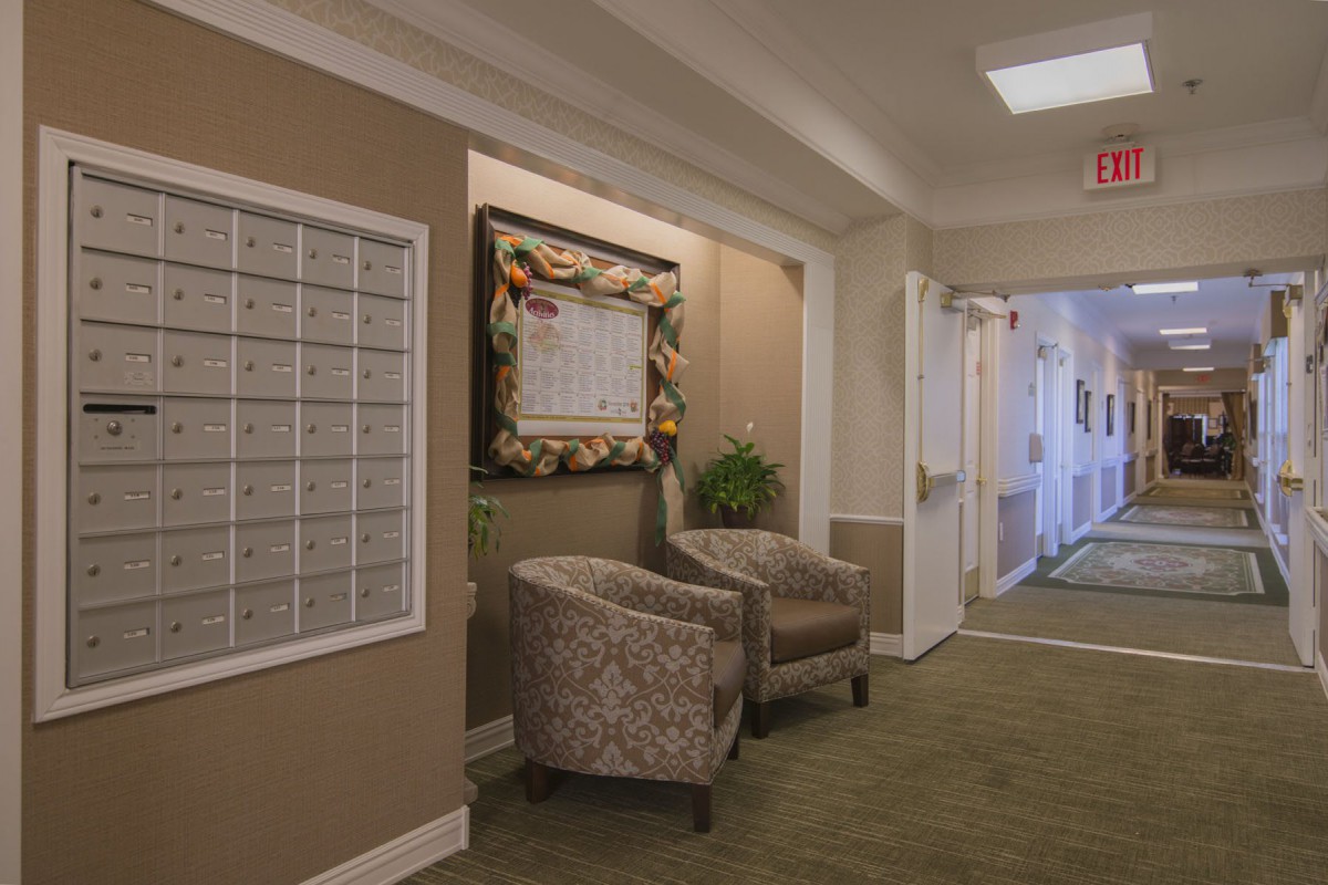A cozy hallway with chairs, mailboxes, and decorative elements.