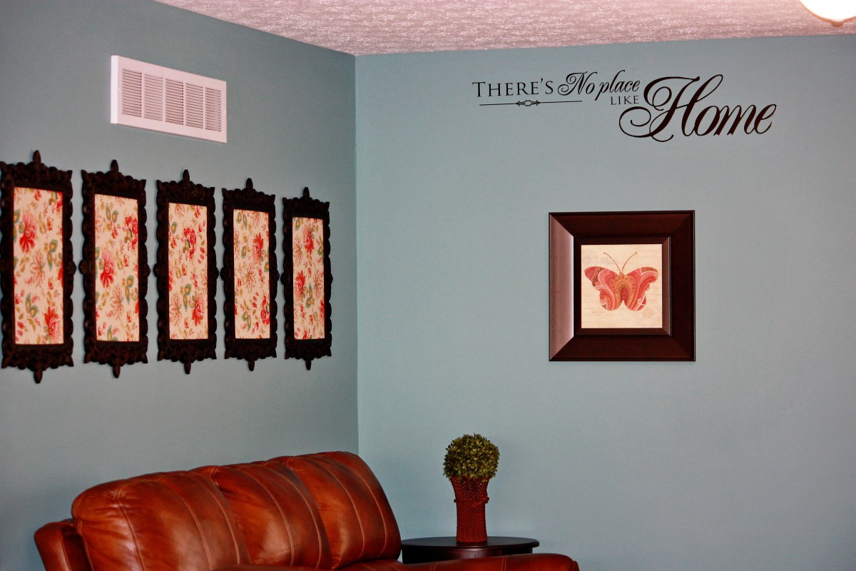 A cozy living room featuring a red leather sofa, decorative wall art, and a comforting quote.