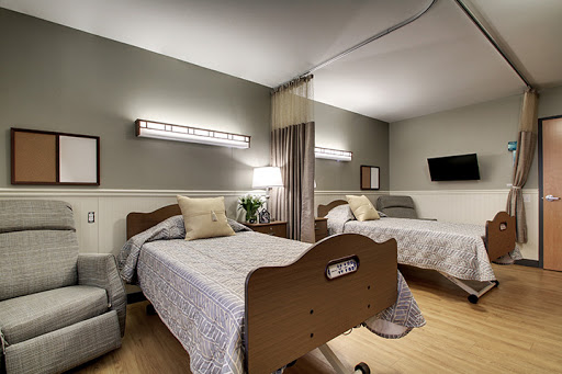 A well-appointed hospital patient room featuring two beds, soft lighting, and a calming atmosphere.