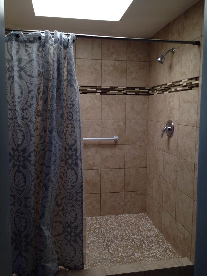 A modern tiled shower area with a decorative curtain.