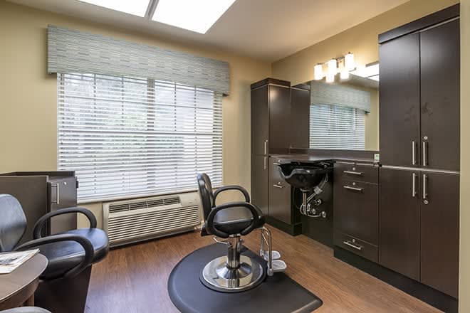 A well-lit hair salon room with styling chairs, mirrors, and modern furniture.