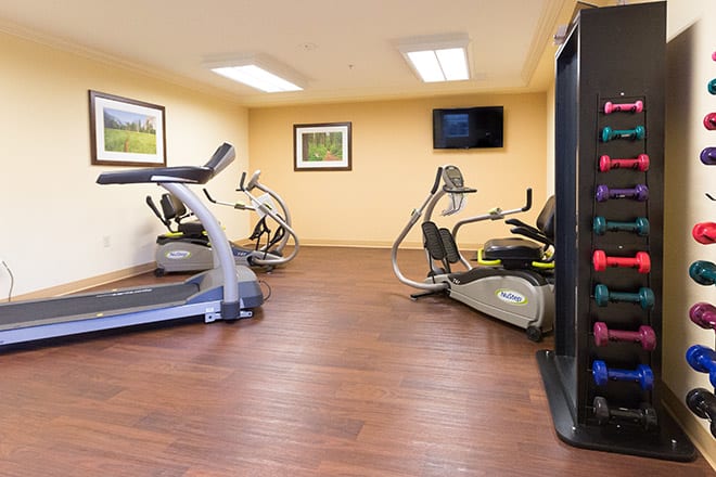 An indoor gym with various exercise equipment including treadmills and stationary bikes.