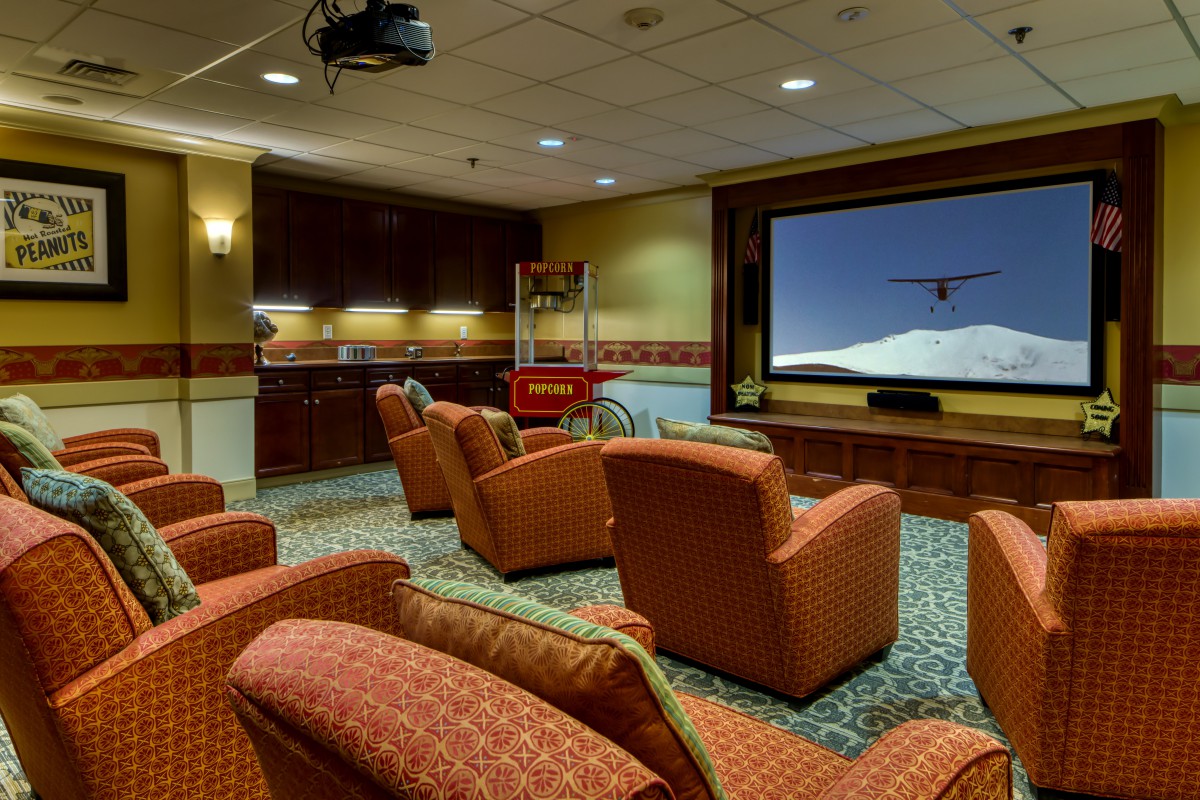 A cozy home theater setup with comfortable seating and a large projector screen.