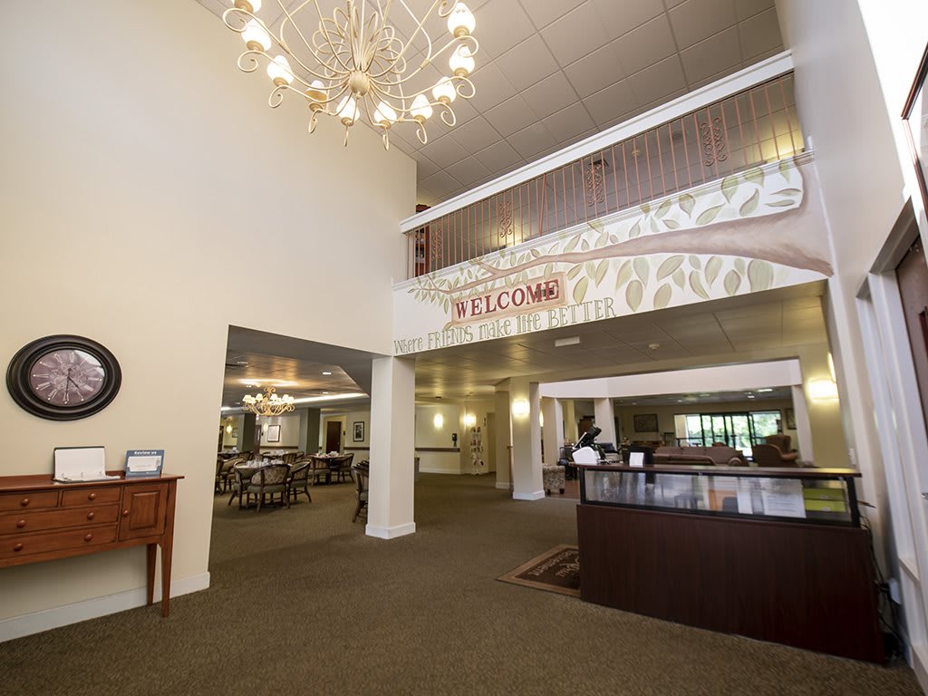 Spacious lobby with a chandelier and reception desk.