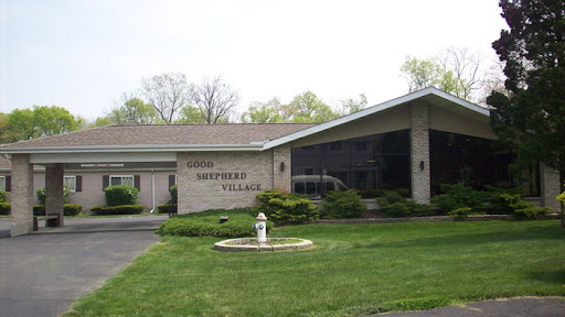 A view of the front entrance of a facility named 'Southern Village' surrounded by well-maintained lawn and landscaping.