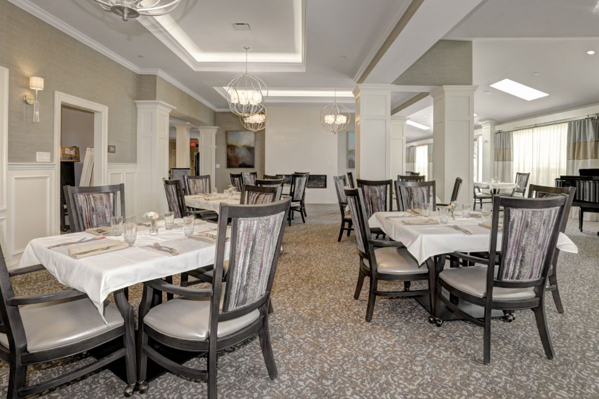 An elegant dining room interior with neatly arranged tables and chairs.