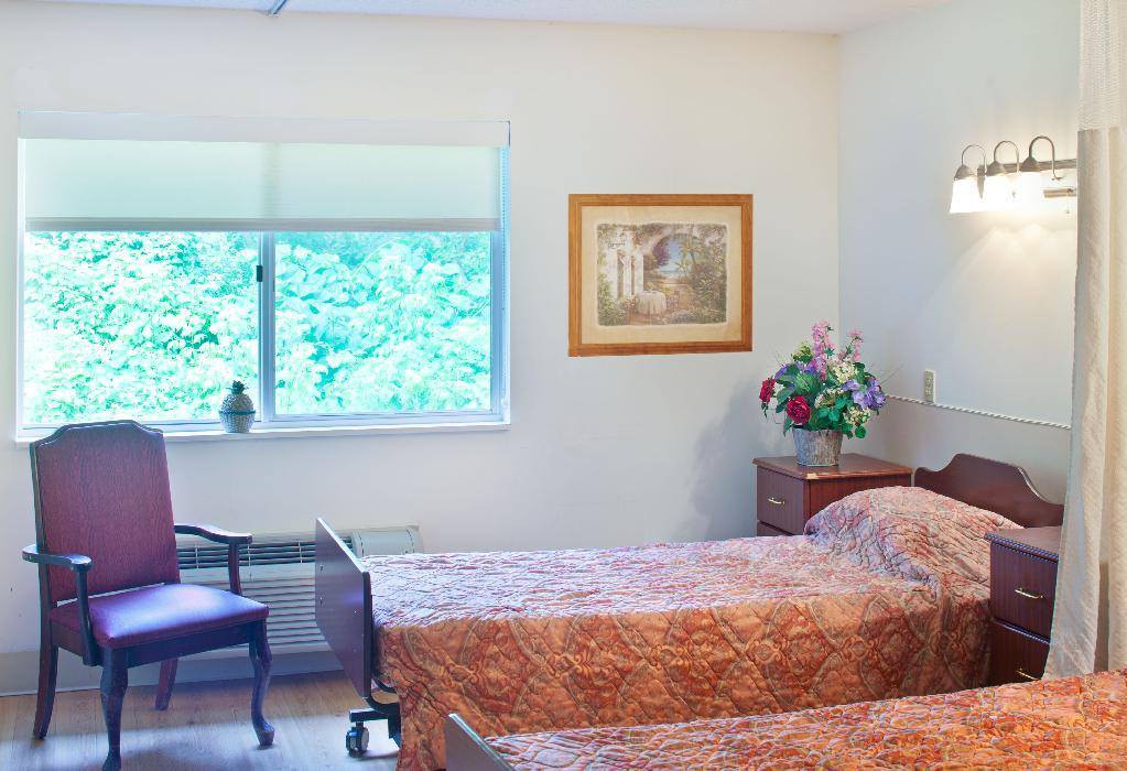 A cozy bedroom with twin beds, a window view, and elegant decor.