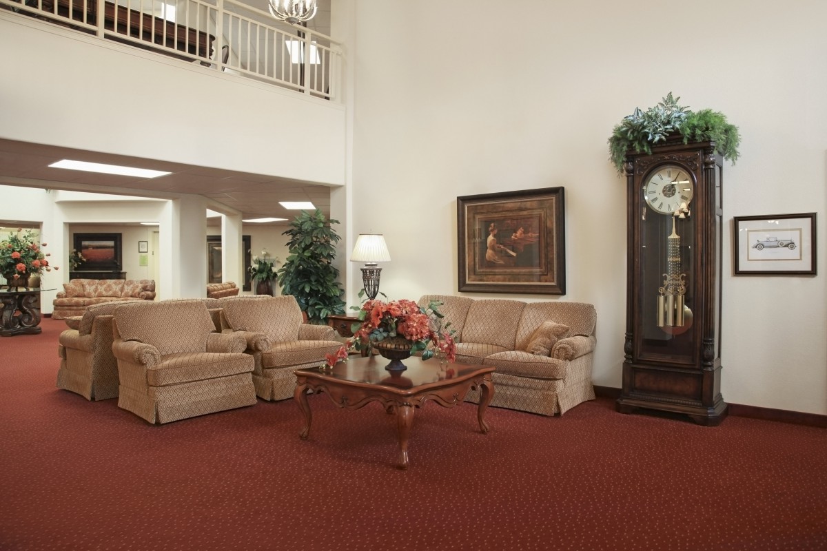 A cozy living room with sofas, a grandfather clock, and decorative elements.