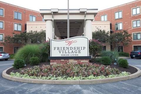 Entrance to Friendship Village with a welcoming garden and sign.