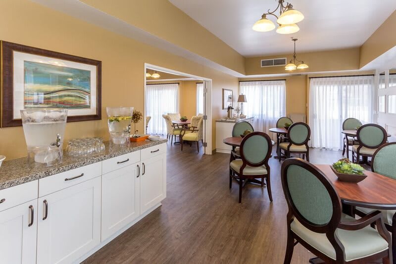 A well-lit dining area with neatly arranged tables and chairs.