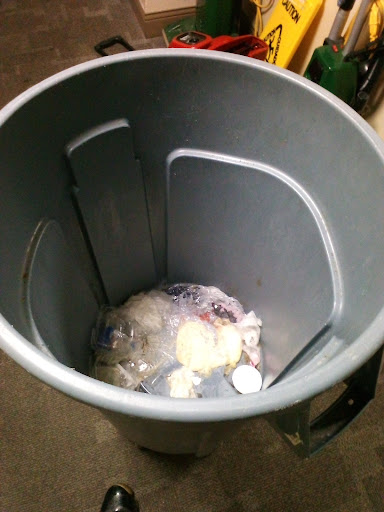 A view inside a garbage can filled with assorted waste.