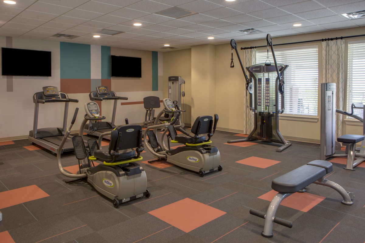 A modern gym equipped with various cardio and strength training machines.