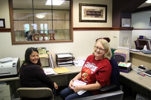 Two women enjoying a moment at their office workspace.