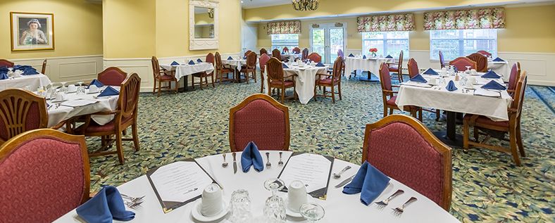 A well-arranged dining room with elegantly set tables and chairs.