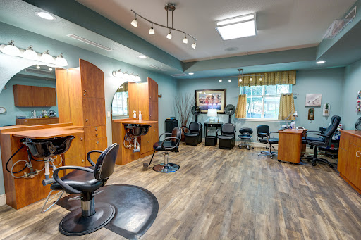 A modern hair salon featuring stylish chairs, wooden accents, and bright lighting.