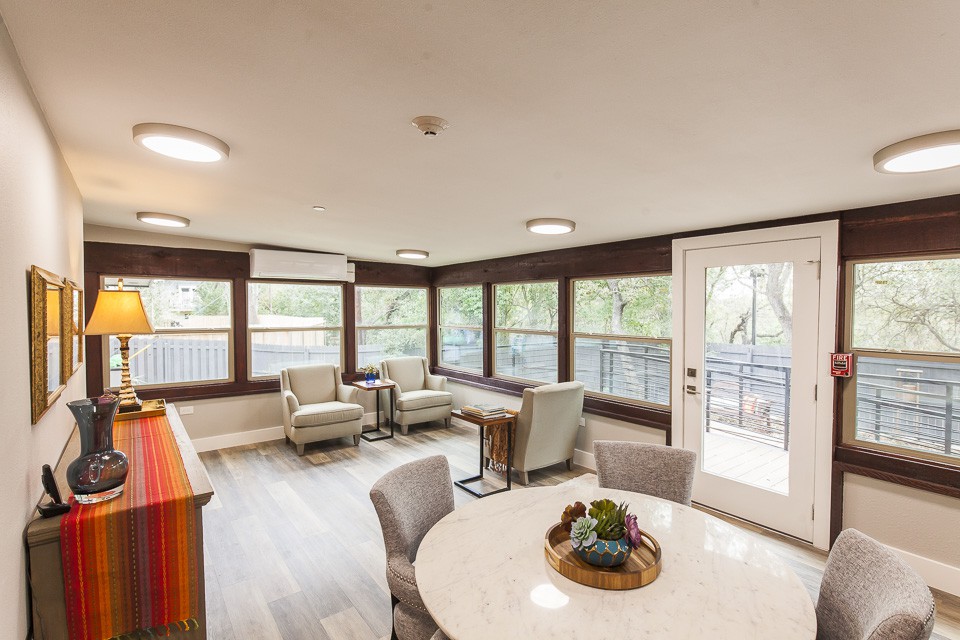 A bright and modern living room with large windows and comfortable seating.