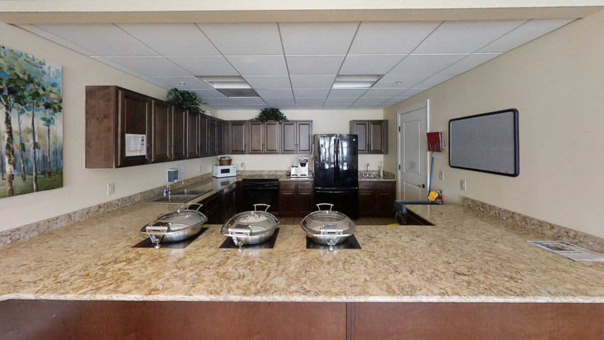 A modern kitchen with a granite countertop and cooking appliances.