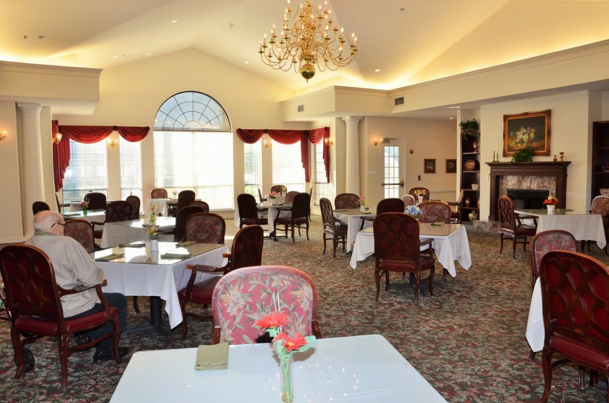 Elegant dining room with a chandelier and red accents.