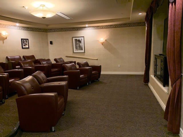A cozy home theater with leather seating and a large screen.
