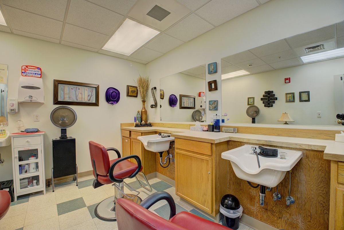 A cozy barbershop interior with chairs, mirrors, and salon equipment.