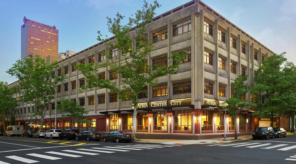 A lit building on a street corner in the evening.