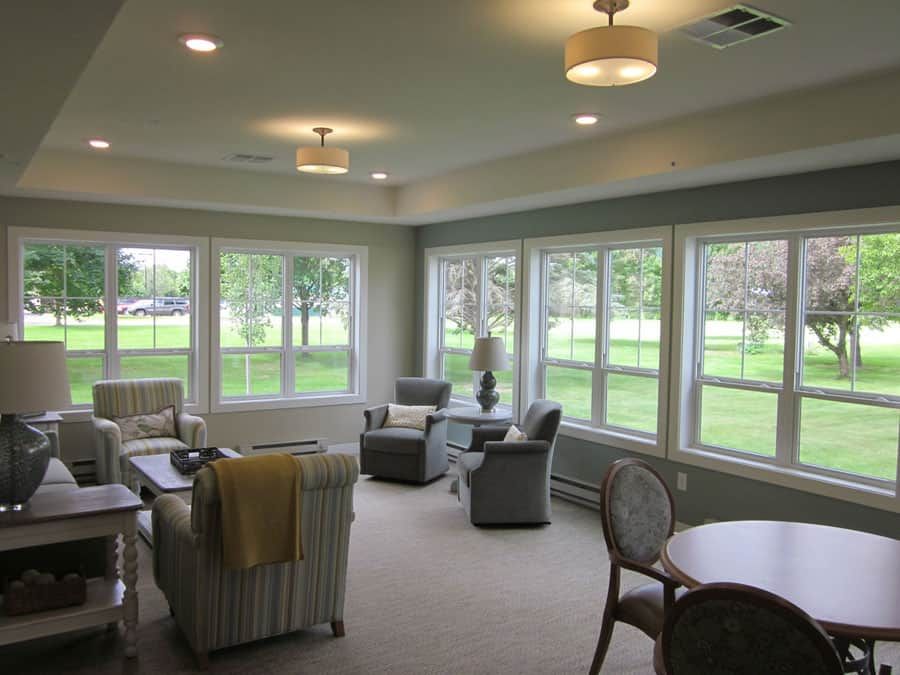 A cozy living room with ample natural light and comfortable seating arrangements.