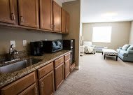 Cozy apartment kitchenette with wooden cabinets and a microwave.