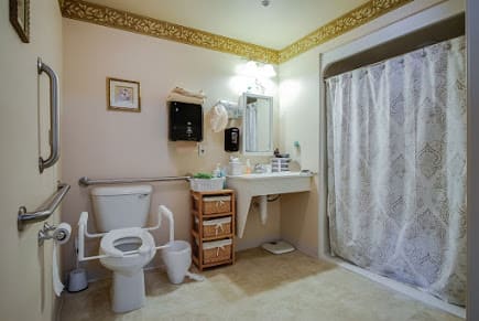 A clean and organized bathroom with a toilet, sink, and shower.