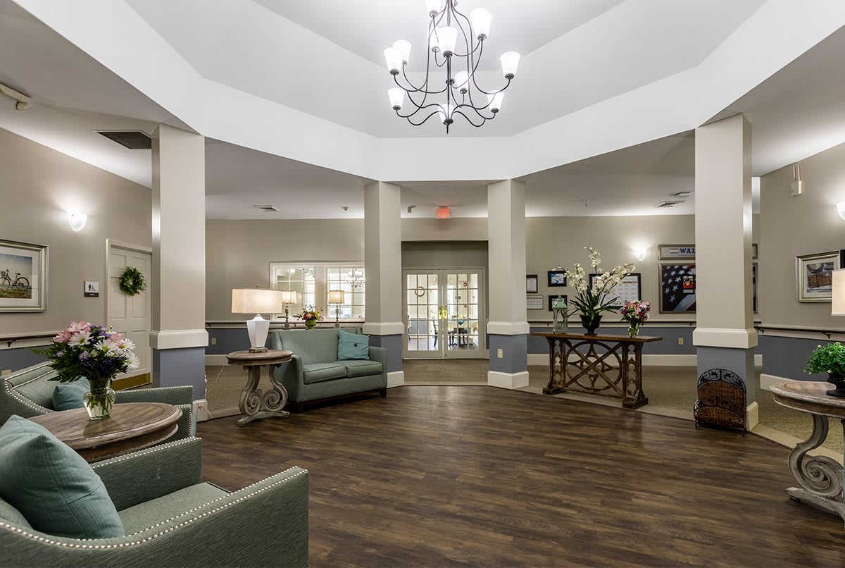 A spacious lobby with elegant decor, featuring a chandelier and comfortable seating.