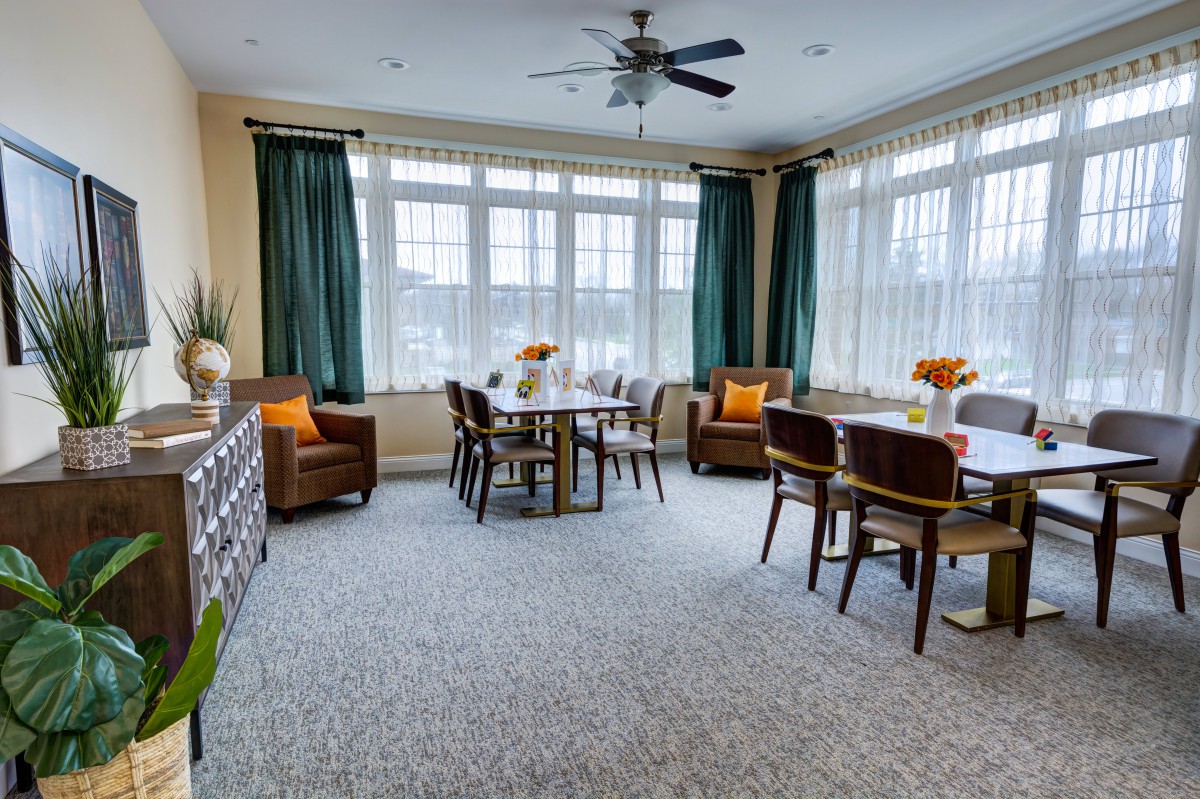 A well-lit dining area with modern furniture and large windows.