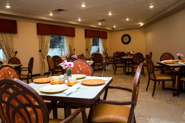A cozy dining room interior with neatly arranged tables and chairs.