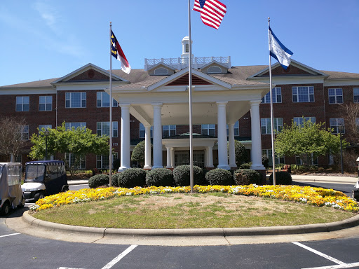 The elegant entrance of a hotel showcasing multiple flags.