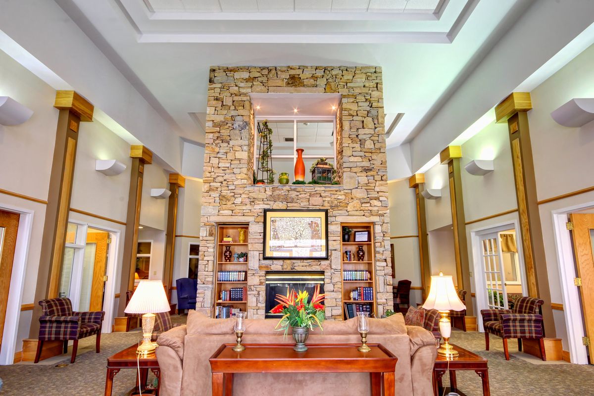 A cozy living room with a large stone fireplace, elegant decor, and comfortable furniture.