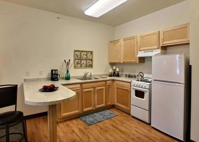 A modern kitchen with wooden cabinets, white appliances, and a countertop.