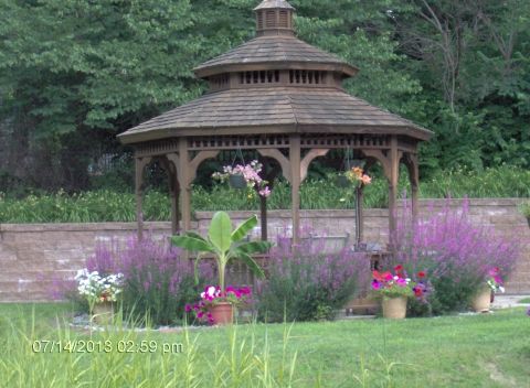 A picturesque garden gazebo surrounded by vibrant flowers and lush greenery.