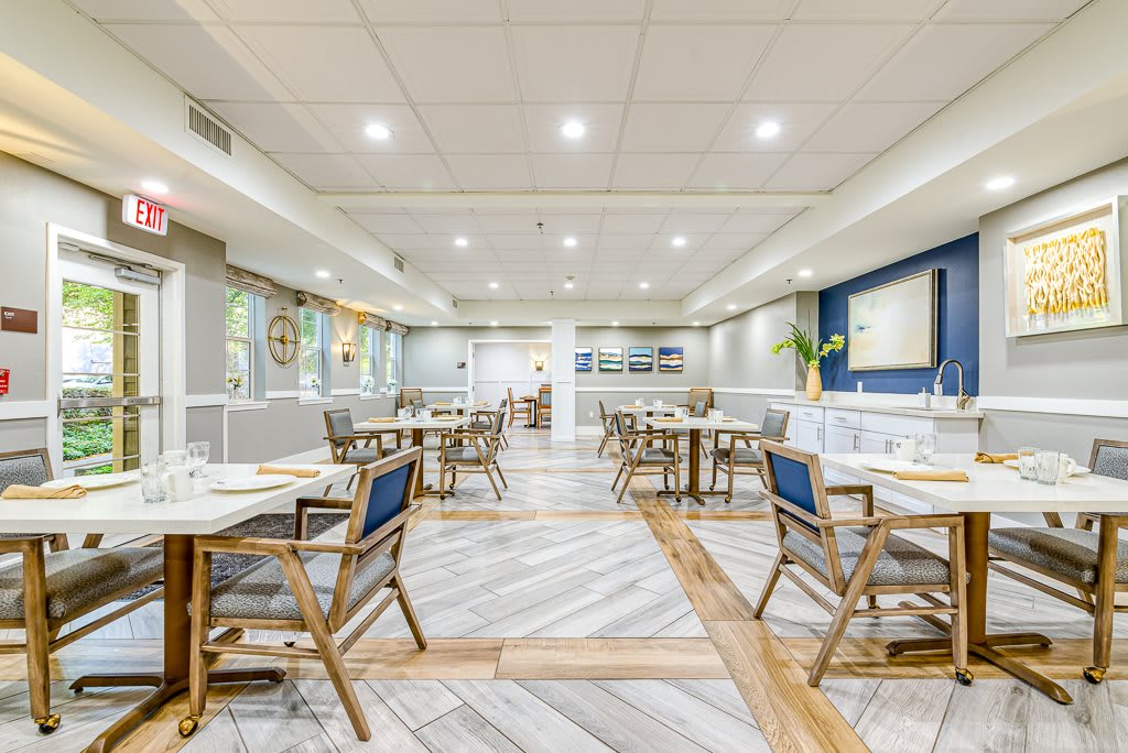 A modern restaurant interior with neatly arranged tables and chairs under bright lighting.
