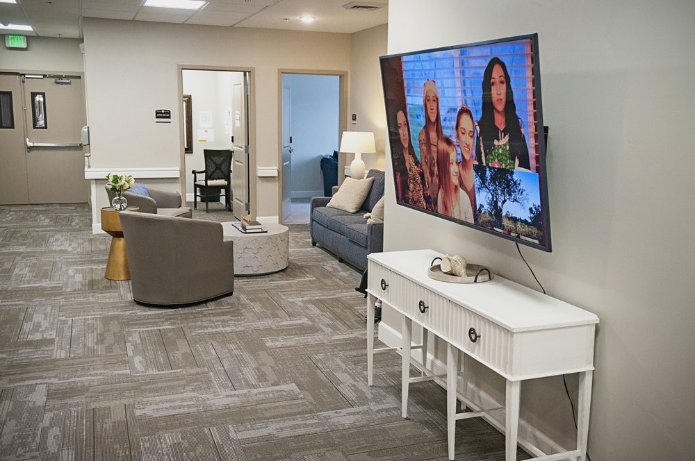 A modern living room with a large TV, comfortable seating, and stylish furnishings.