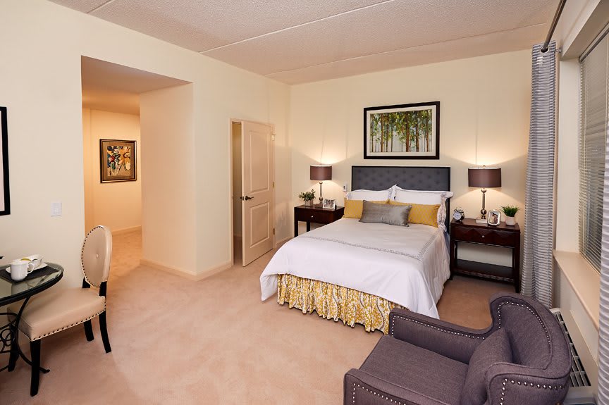 A cozy hotel room with a neatly made bed, bedside lamps, and elegant decor.