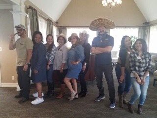 A group of people posing indoors, some wearing hats.