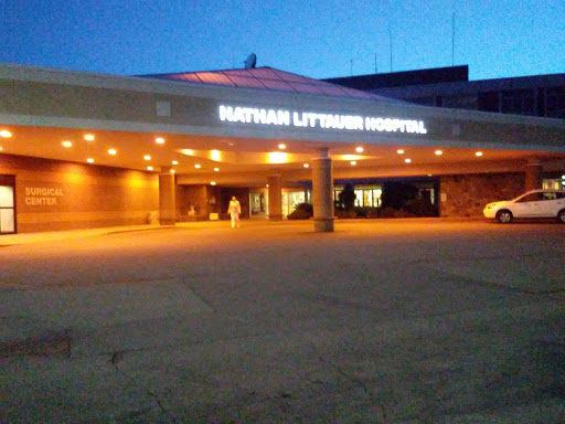 Exterior view of a hospital at night, illuminated with outdoor lighting.
