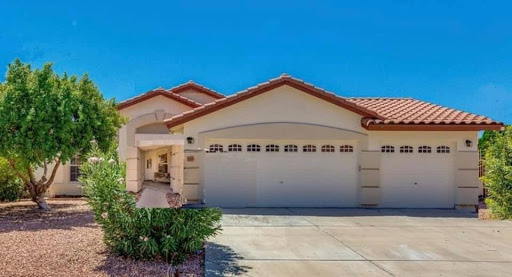 A beautiful residential house featuring a two-car garage and a landscaped front yard.
