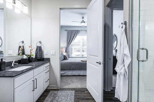 A modern bathroom with a view of a stylish bedroom, showcasing clean lines and neutral tones.