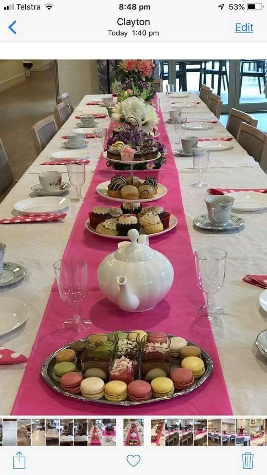 A beautifully set table for an afternoon tea party, complete with a variety of desserts and elegant china.