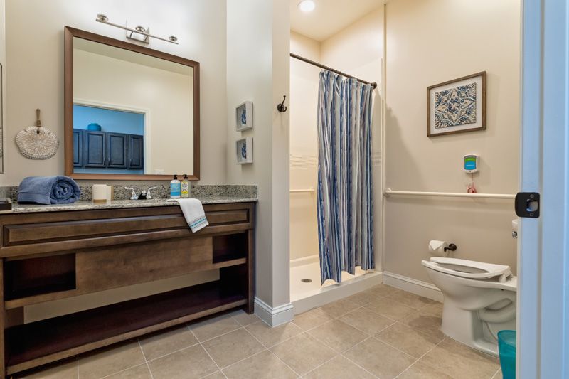 Modern bathroom with a vanity sink, shower, and toilet.