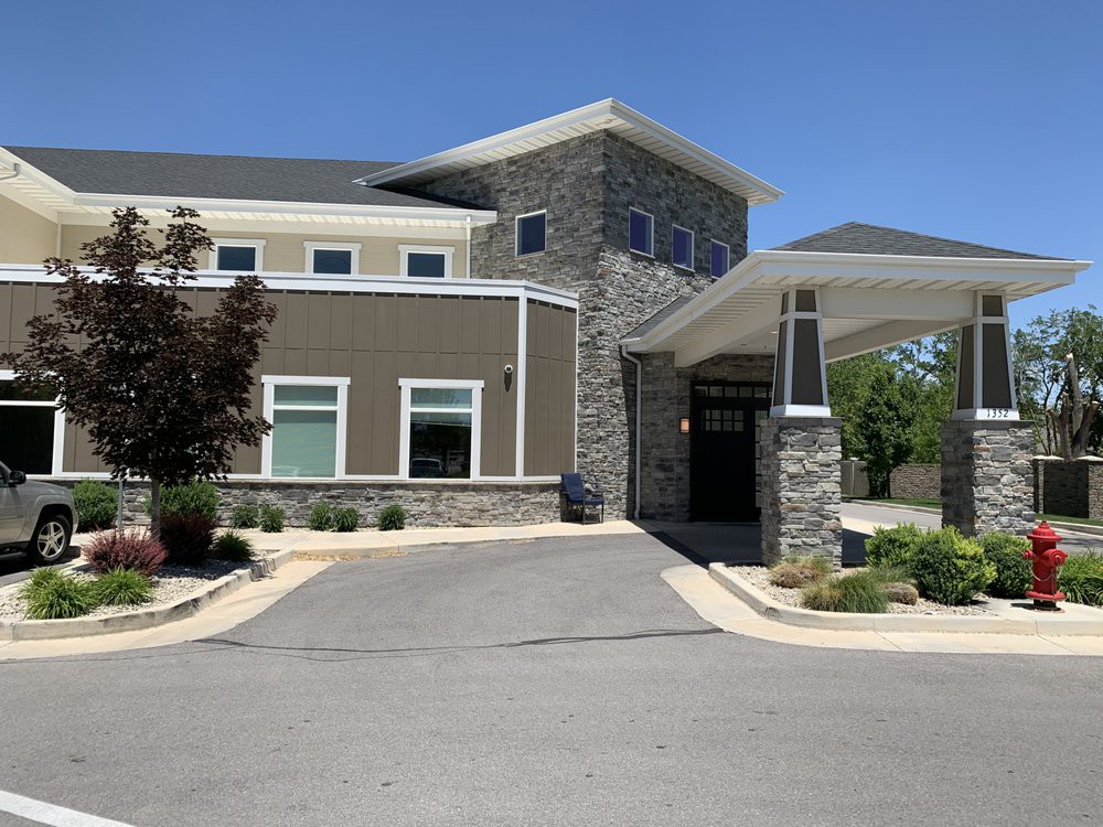 A modern office building with a stone facade and a covered entrance.