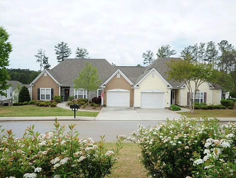 A row of suburban houses with manicured lawns and driveways.