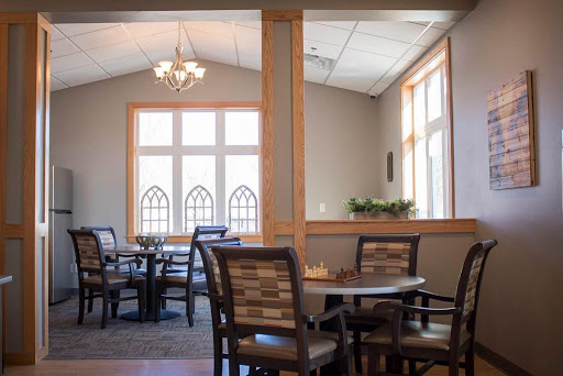 A spacious and elegantly designed dining area with natural light filtering through large windows.