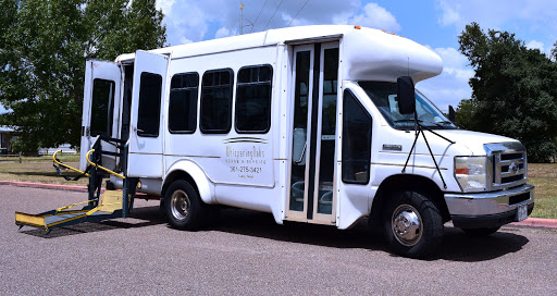A white shuttle bus parked, ready for passengers.