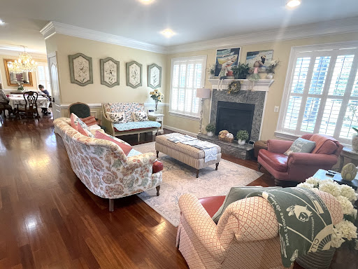 A cozy living room featuring comfortable seating, a decorative fireplace, and elegant wall art.