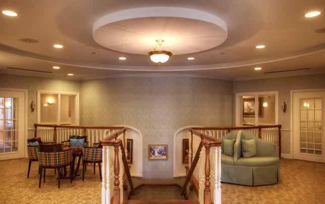 A cozy interior space featuring a staircase, seating area, and elegant lighting.